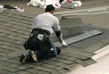 Roofing constructor installing shingle roof close up