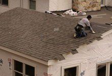 Roofing constructor installing shingle roof