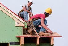 Two contractors repairing roof