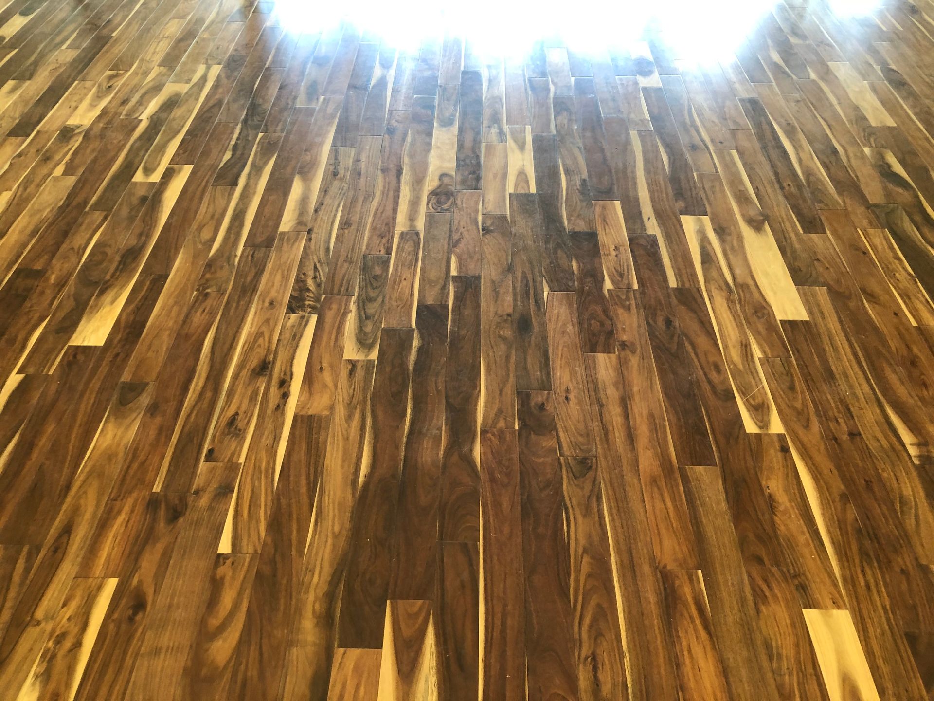 Polished wooden floor with bright light shining from the top edge