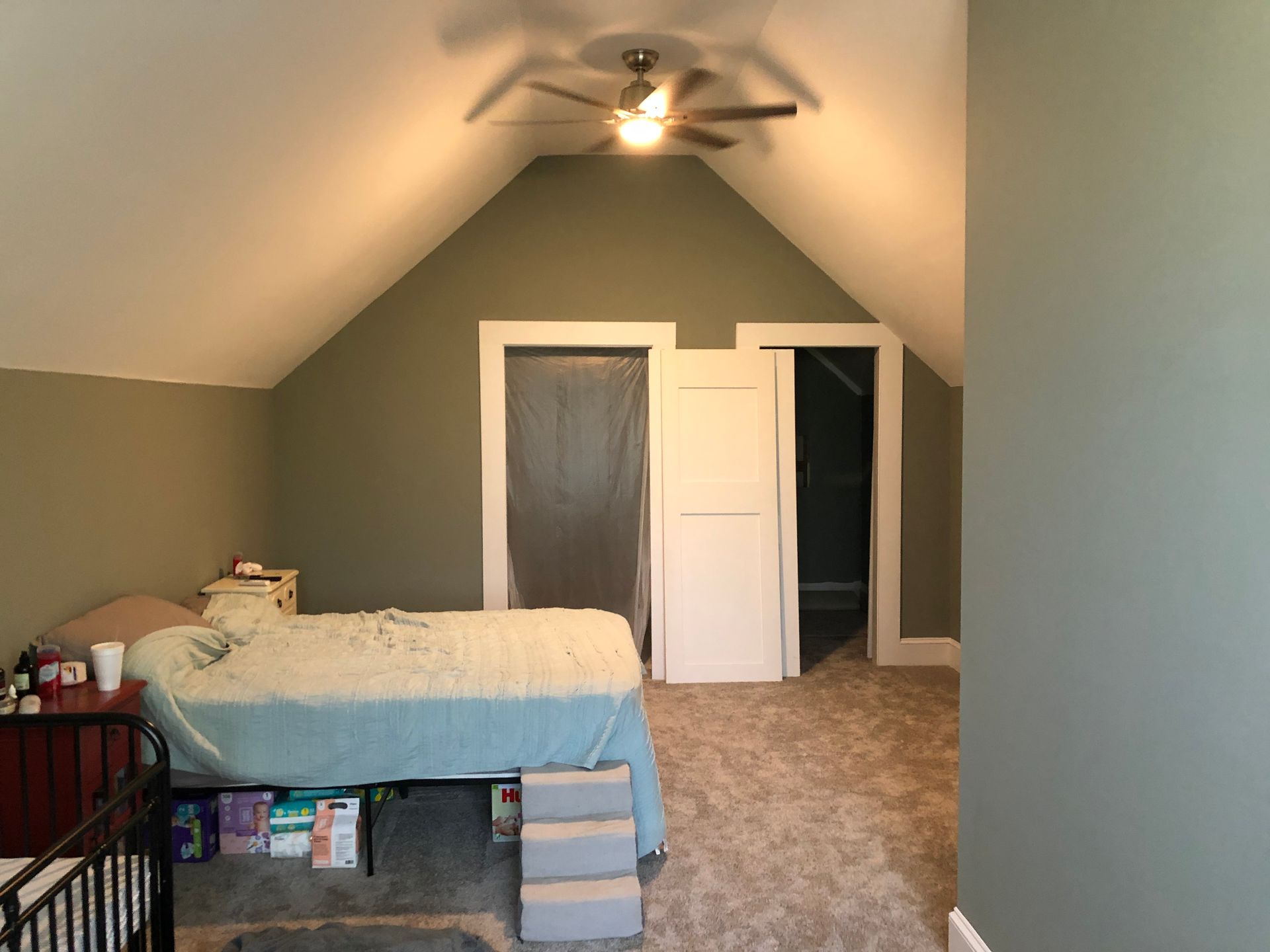 Attic bedroom with a bed, ceiling fan, and carpeted floor