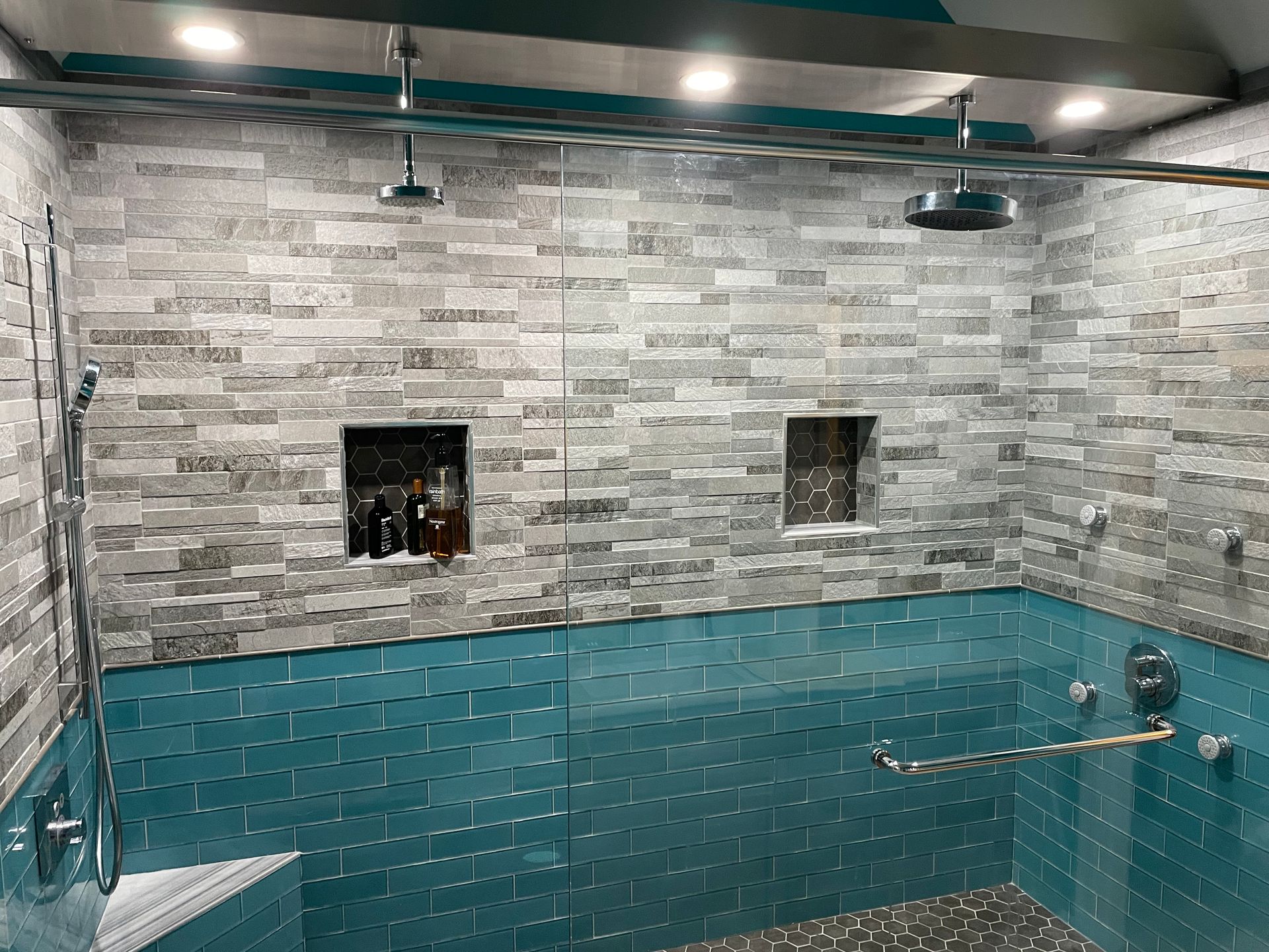 Indoor pool with turquoise water and gray stone walls, viewed from above.