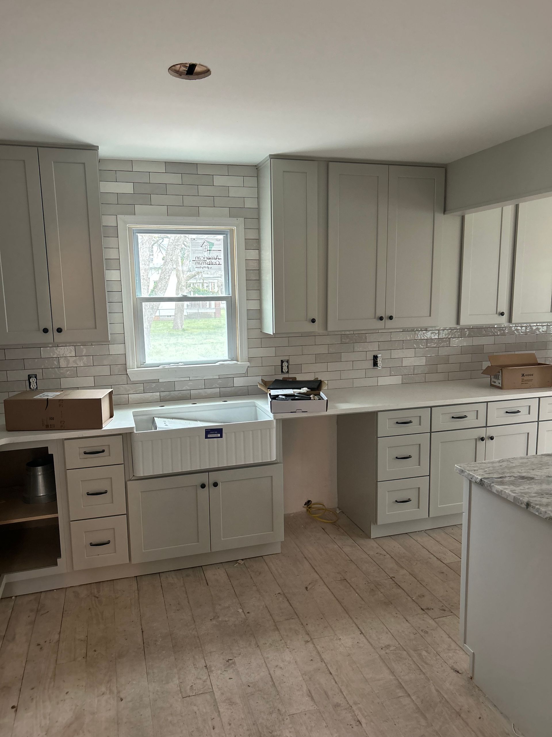 Bright kitchen with white cabinets, granite countertops, and a window over the sink.