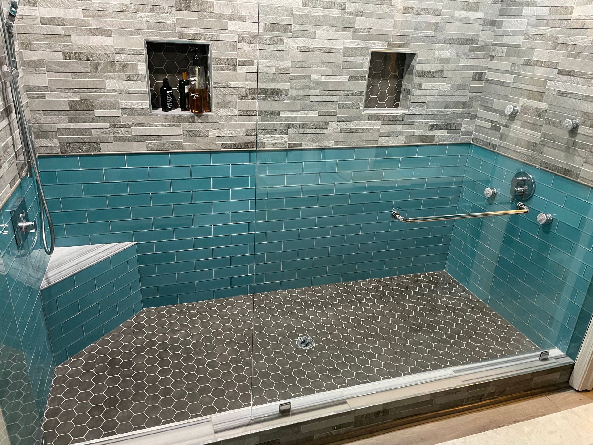 Small indoor tiled pool or hot tub with turquoise water and gray stone walls