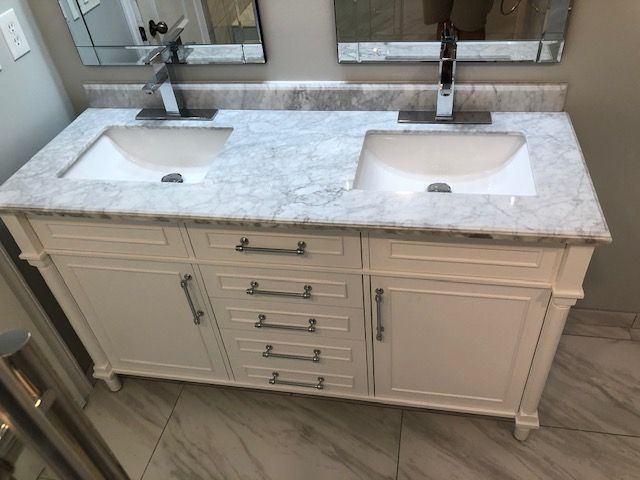 White double-sink bathroom vanity with marble countertop and large mirrors