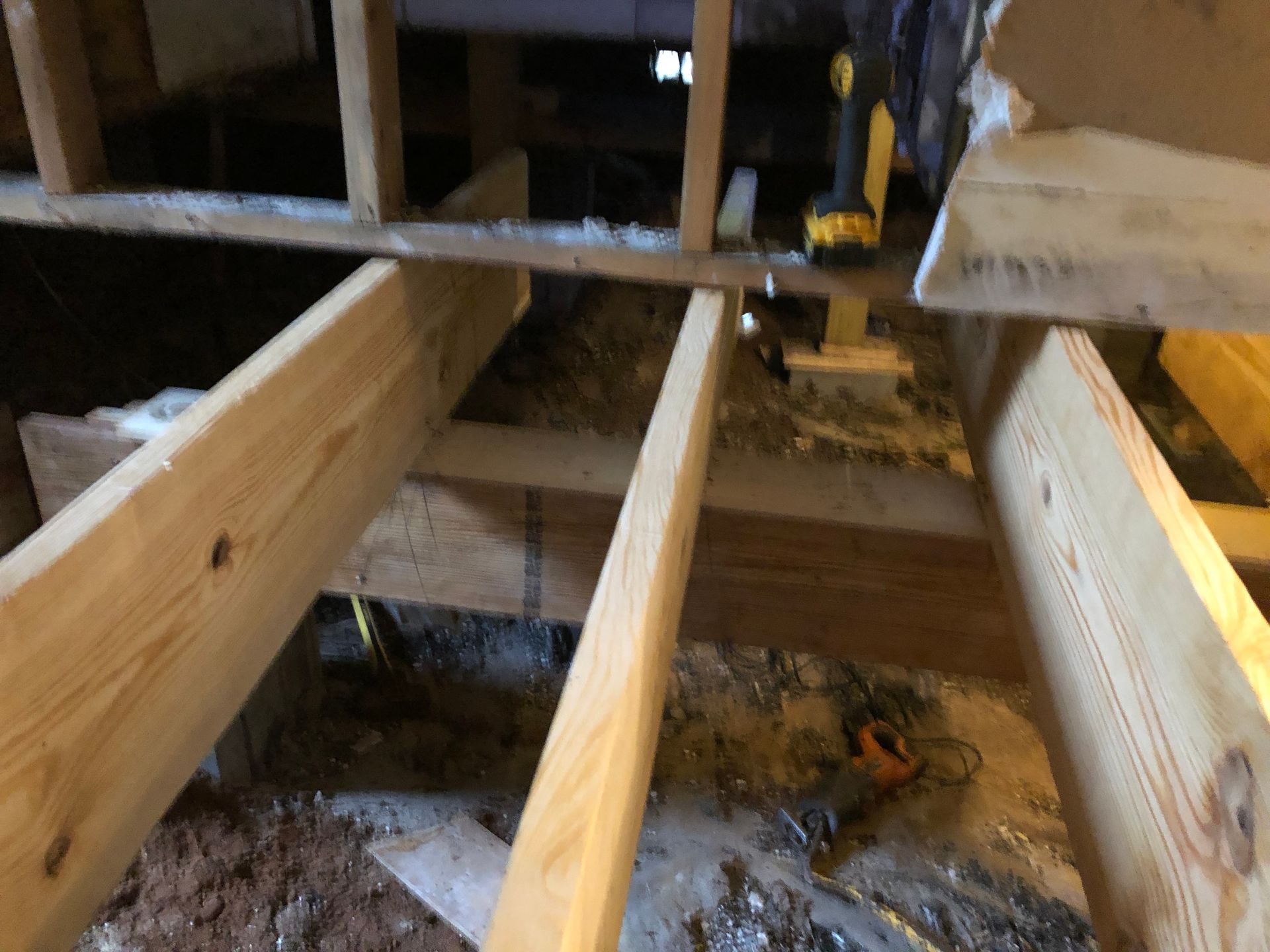 Open floor joists and framing inside a partially demolished room