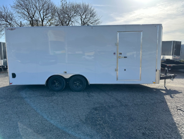 White enclosed trailer on an outdoor surface, with two wheels and a door on the side.