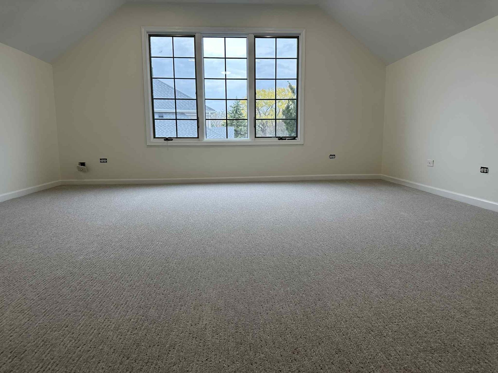 Empty room with beige carpet, white walls, and a large window.
