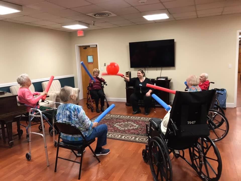 Seniors in wheelchairs and chairs playfully