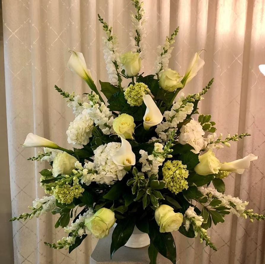 White floral arrangement with roses and lilies.