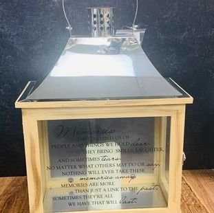 Light wooden lantern with silver top and glass sides inscribed with a poem about memories.