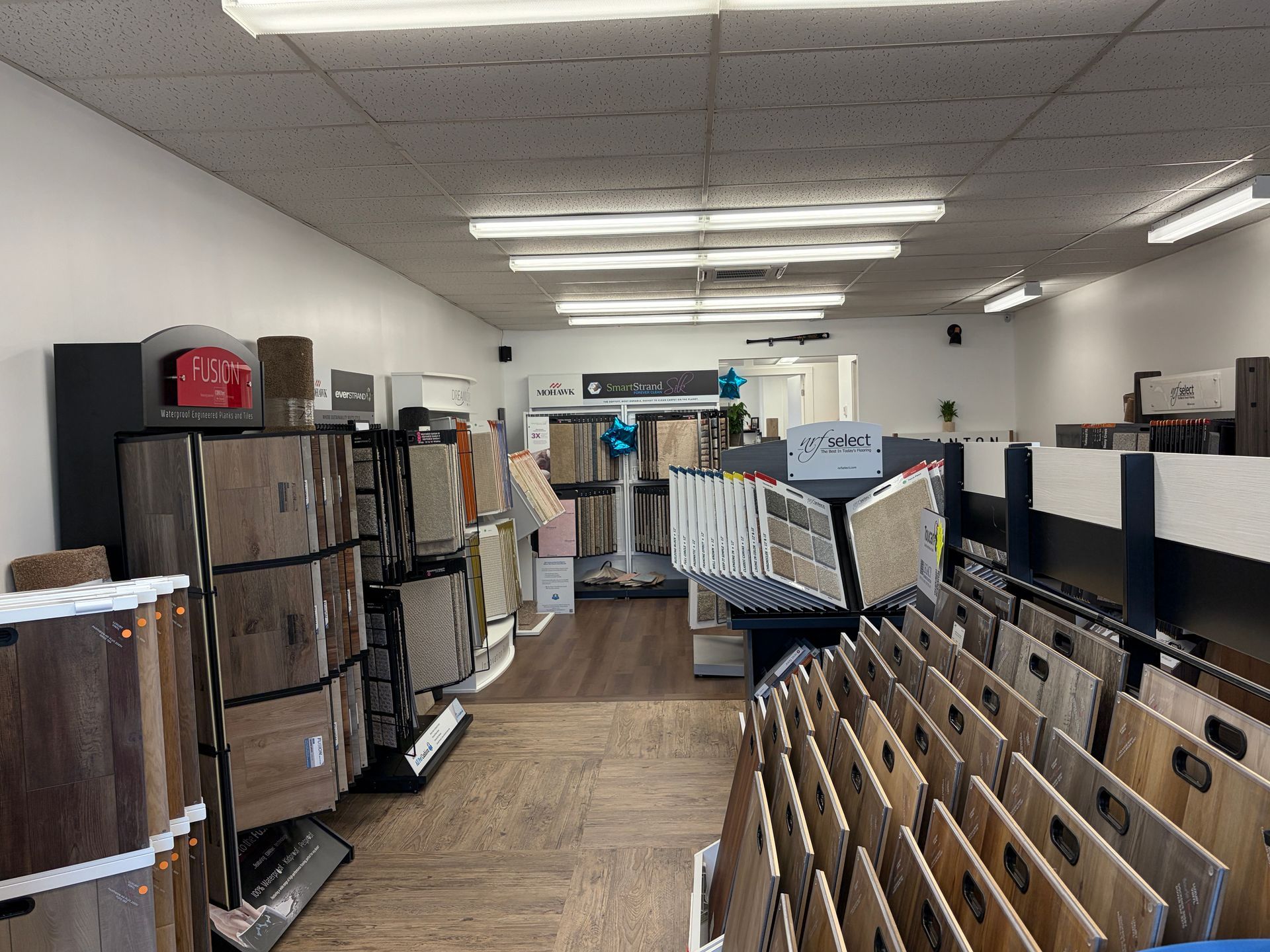 Interior of a flooring store showcasing various samples on display racks under bright lighting.