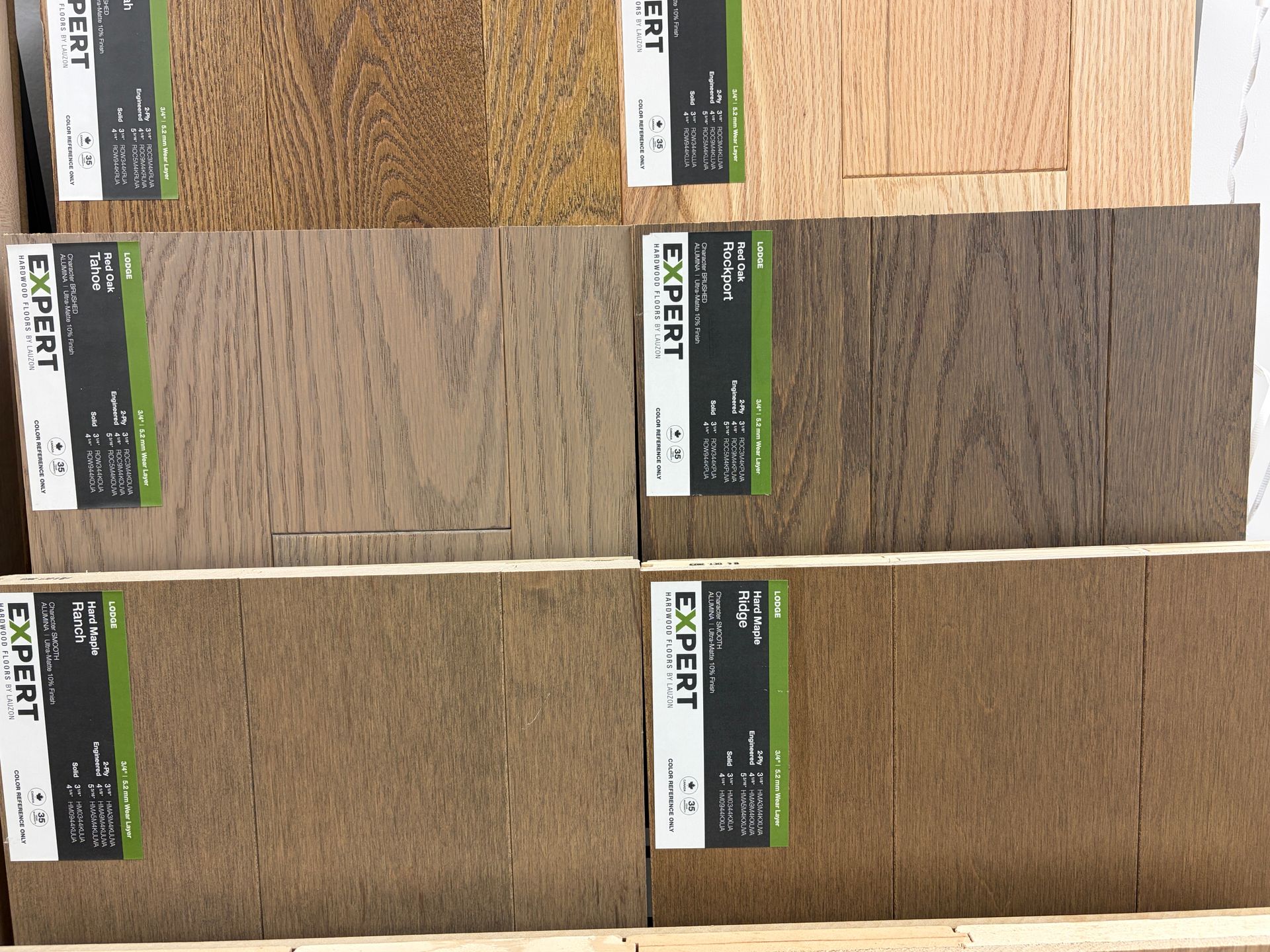 Samples of wooden flooring with labels, various brown hues.