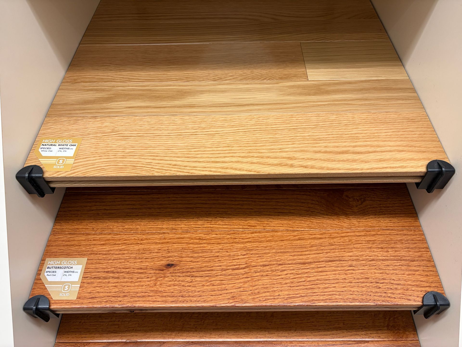 Display of three wooden flooring samples, varying in color from light to medium brown.