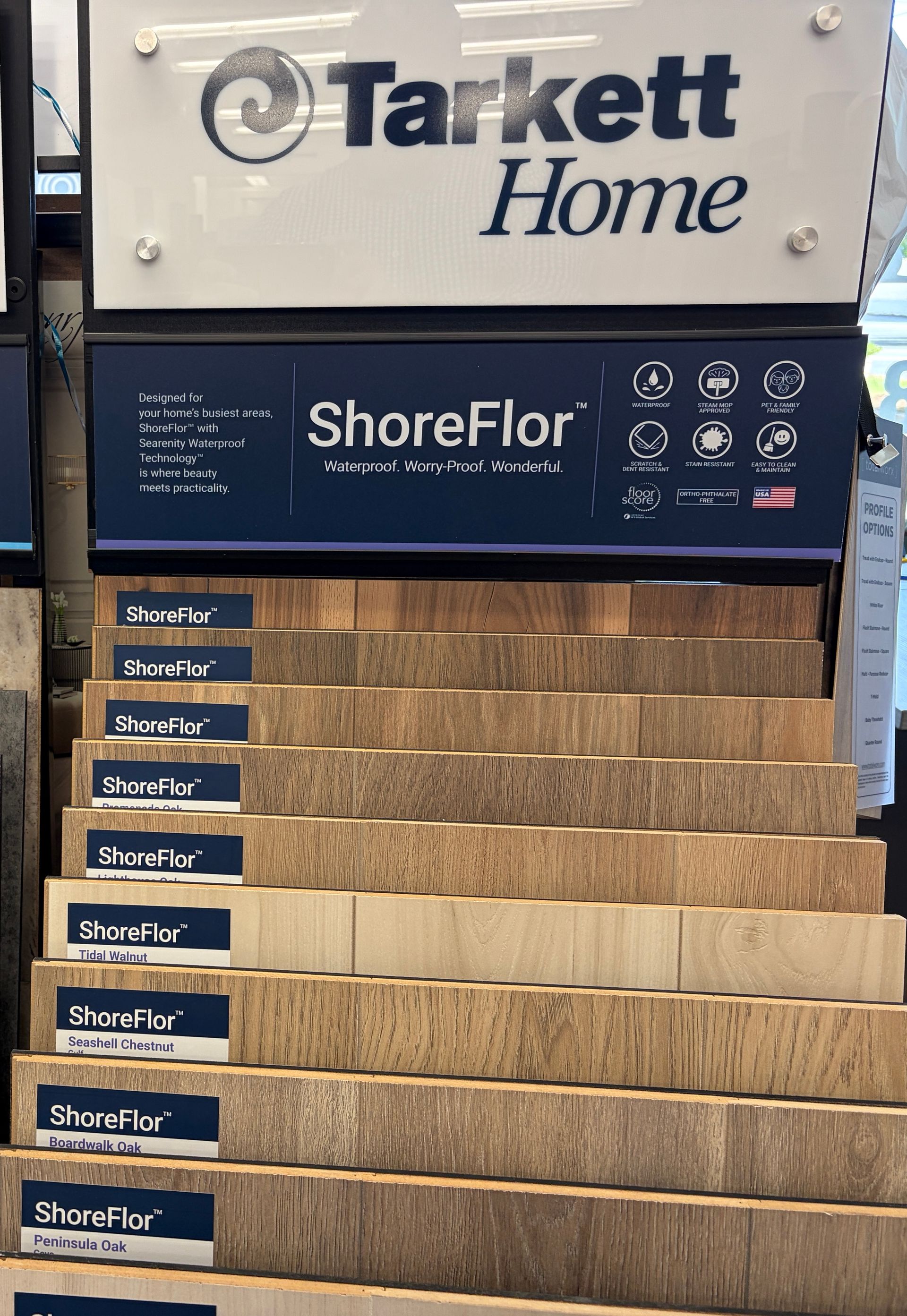Display of Tarkett Home ShoreFlor flooring samples. Various wood-look planks arranged in steps.