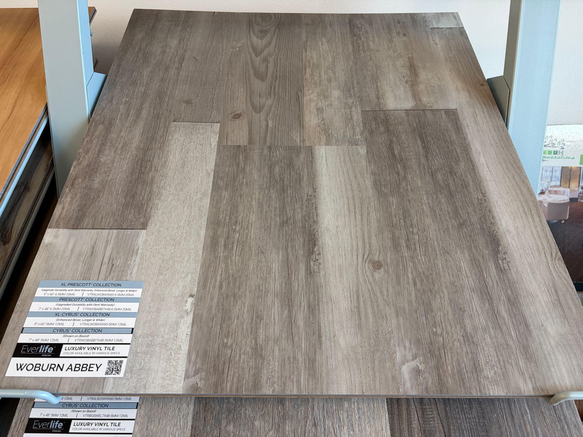 Wood flooring samples in gray tones on display.