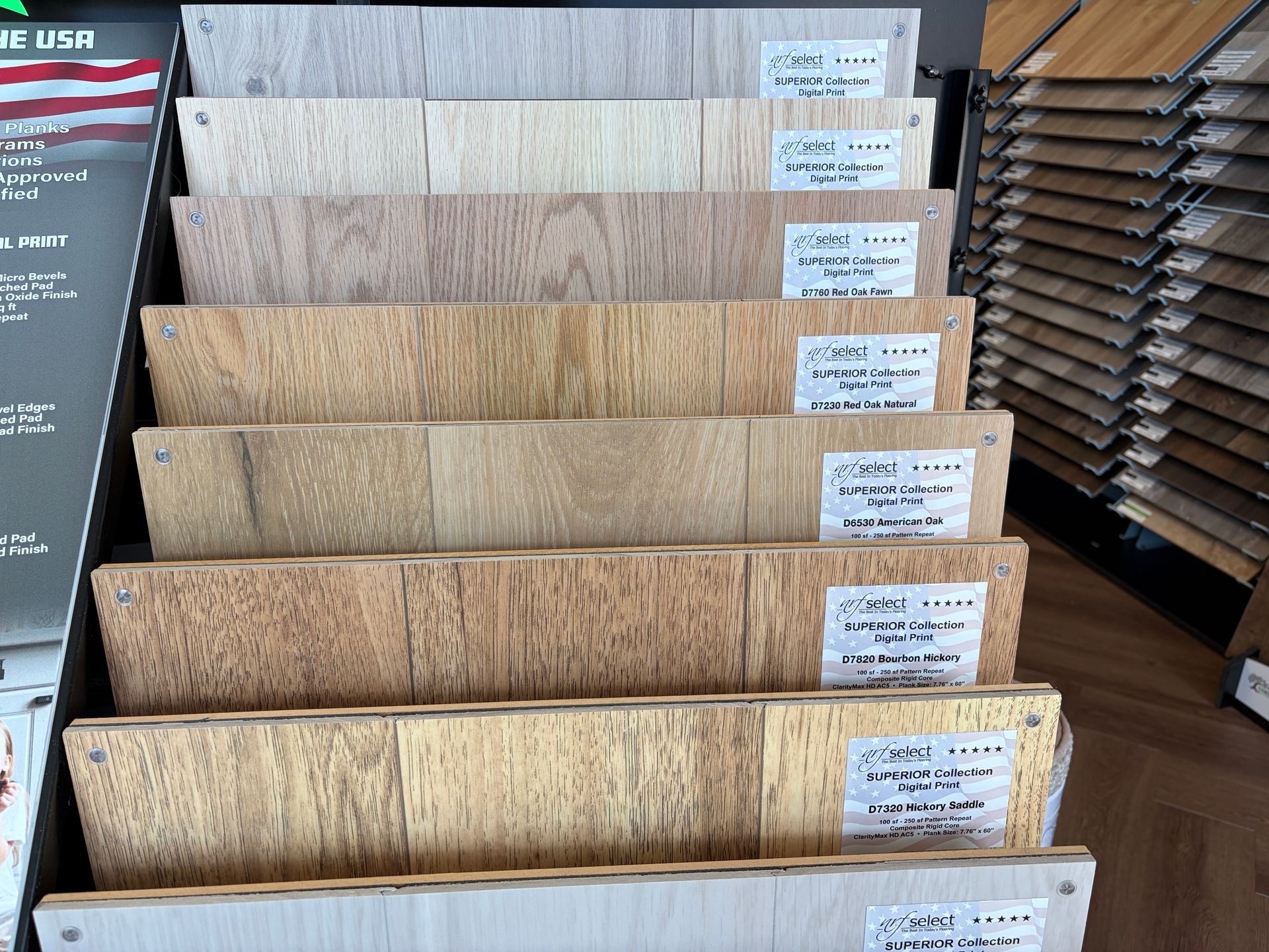 A display of various wood flooring samples in different shades, organized by color, indoors.