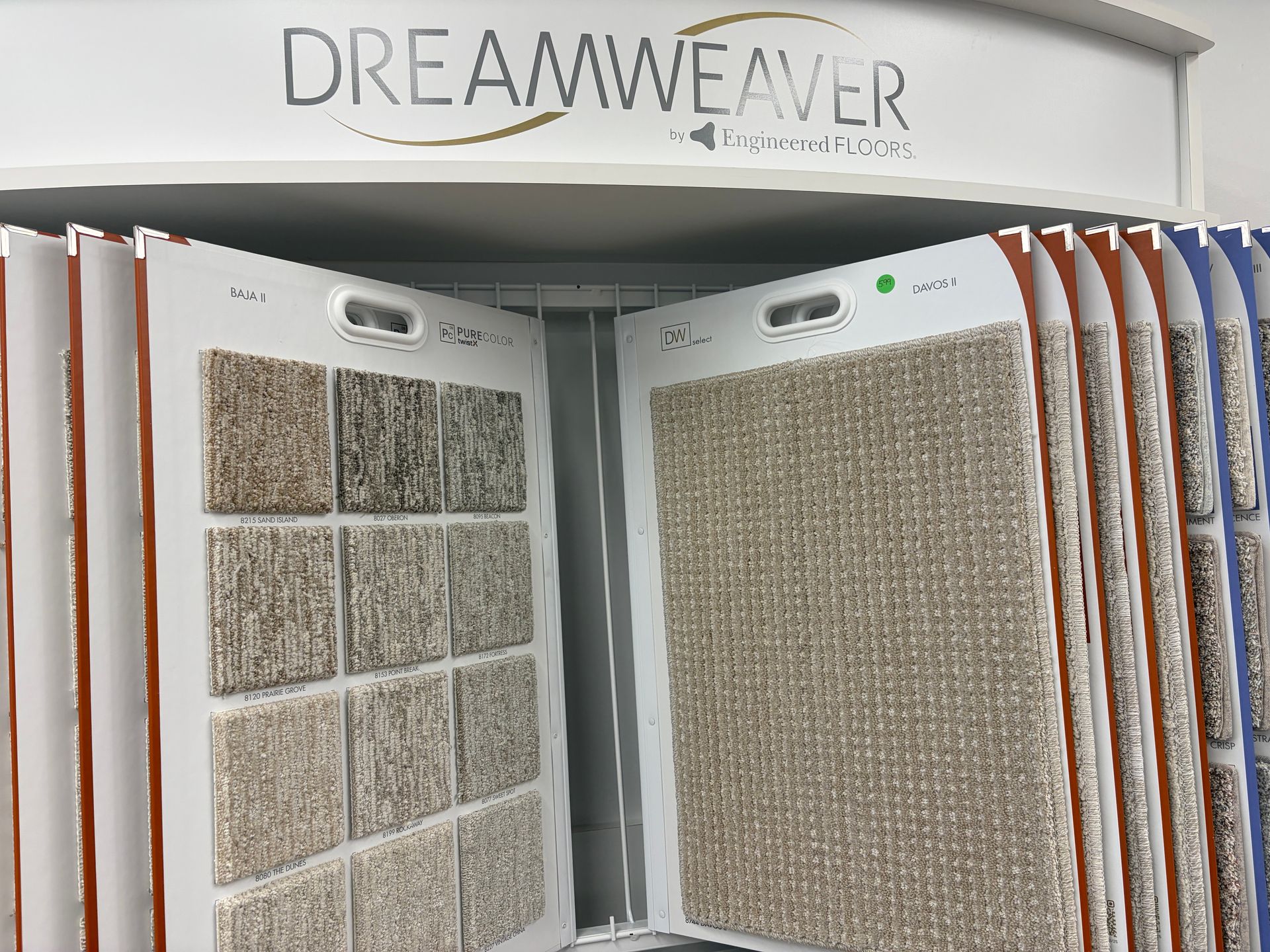 Carpet samples displayed on a rotating rack, DreamWeaver logo above.