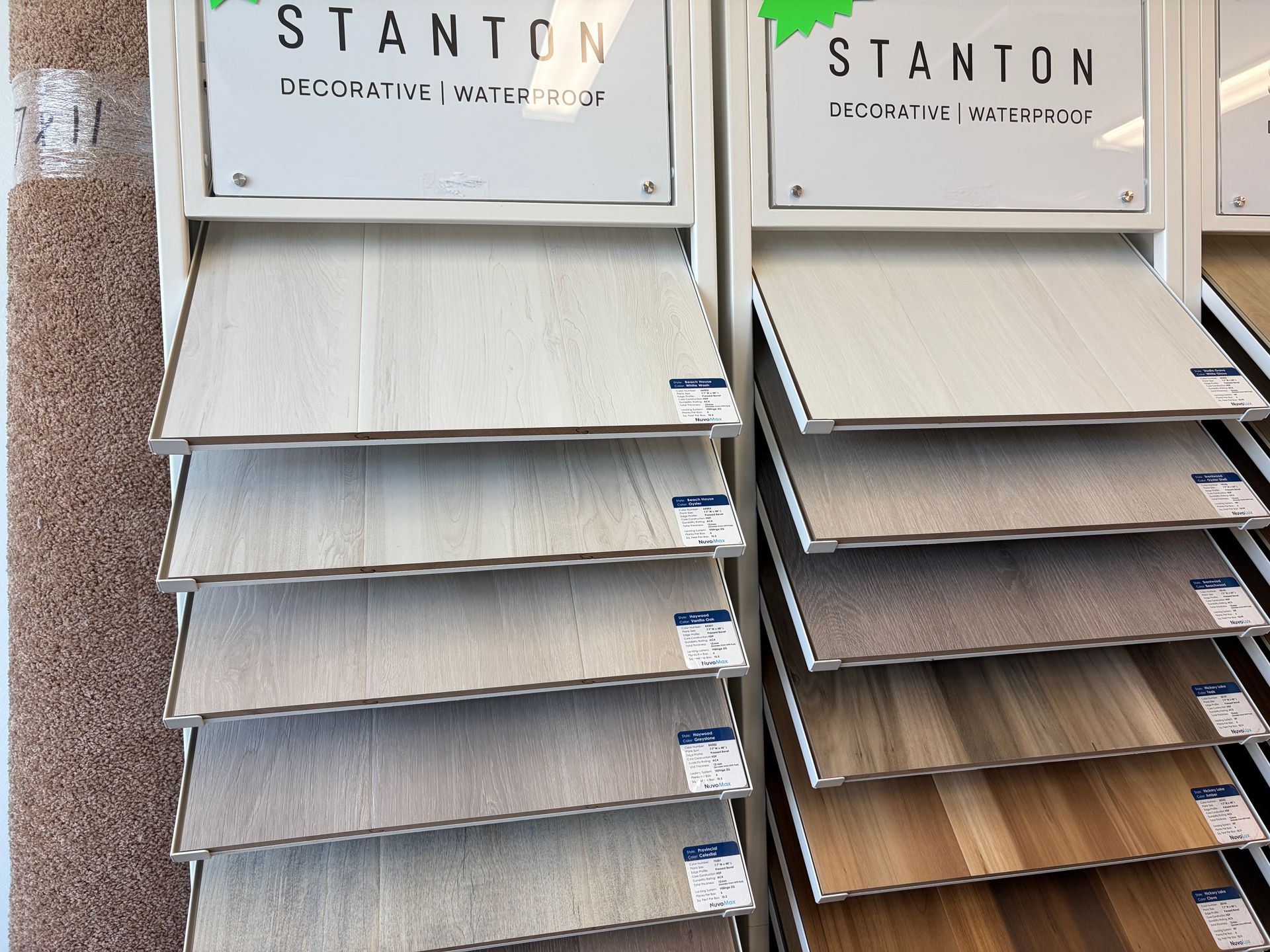 Display of Stanton decorative vinyl flooring samples in various wood grain colors.
