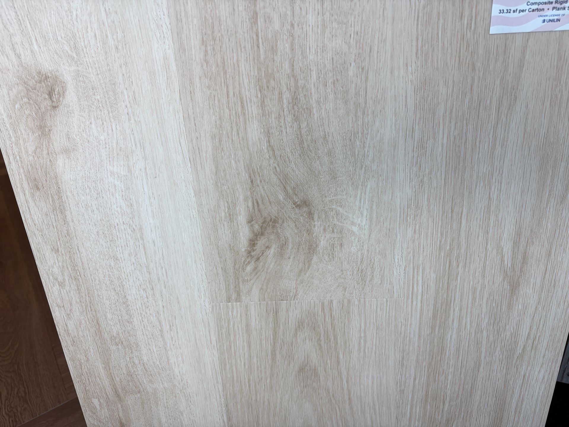 Light-colored woodgrain pattern, possibly flooring or a panel, with varying shades of beige and brown.