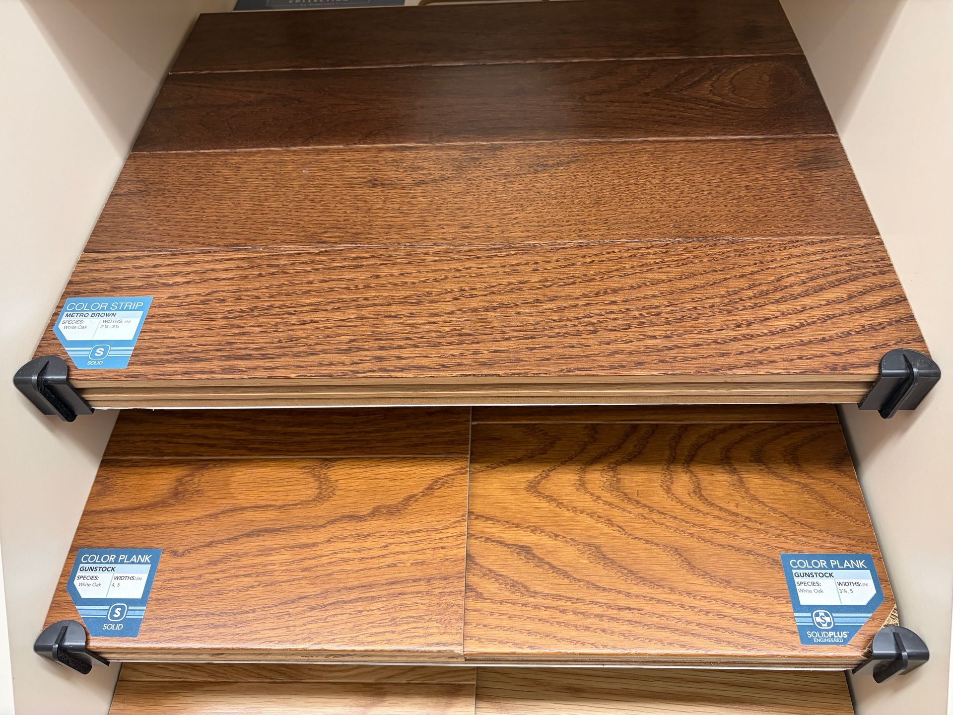 Wooden flooring samples in various shades of brown displayed in a store.
