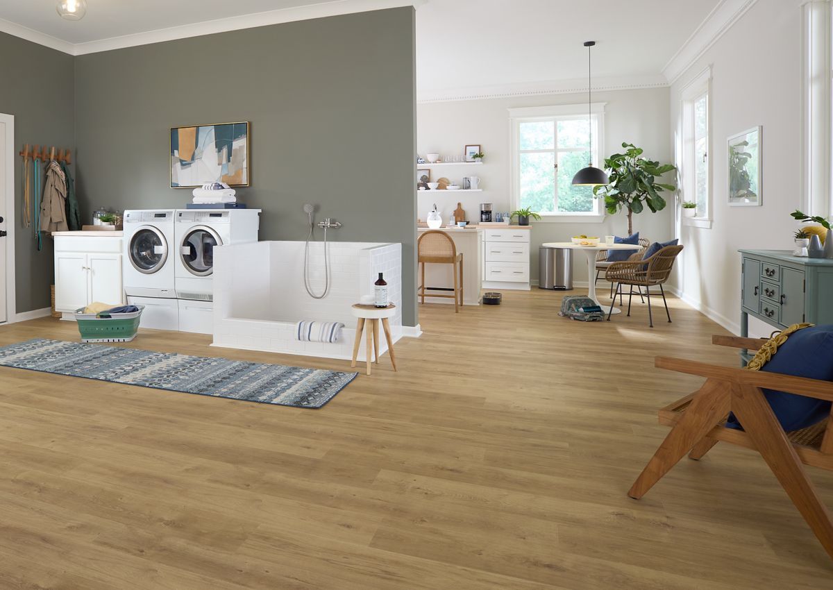 Laundry room with washer/dryer, dog wash station, light brown flooring, and dining area.
