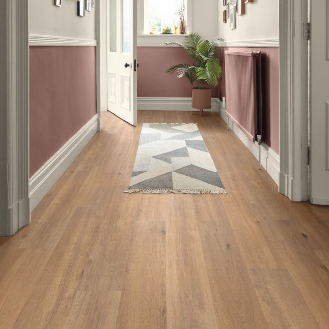 Hallway with light wood floor, dusty rose walls, and geometric runner rug.