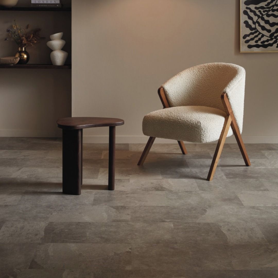 Cozy living room with cream sherpa chair, dark wood side table, and beige wall.