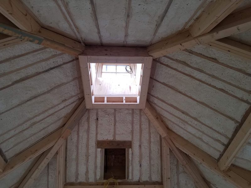 Wooden interior with skylight and small window.