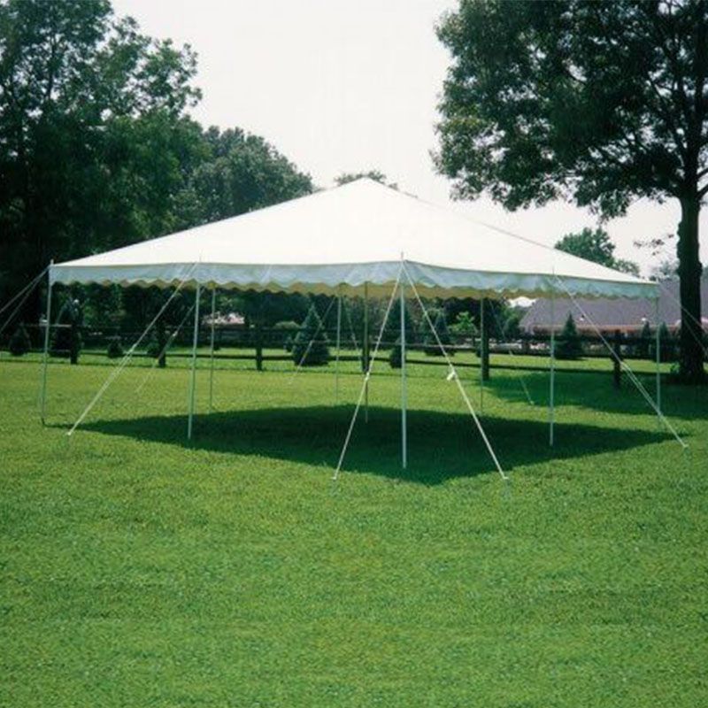 A white tent is sitting in the middle of a lush green field