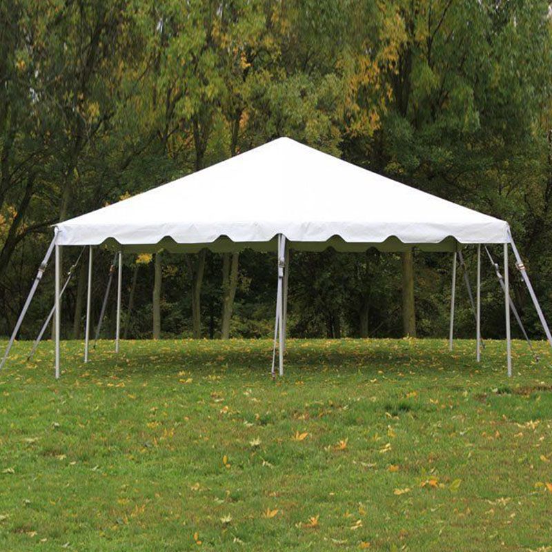 A white tent is sitting in the middle of a grassy field.