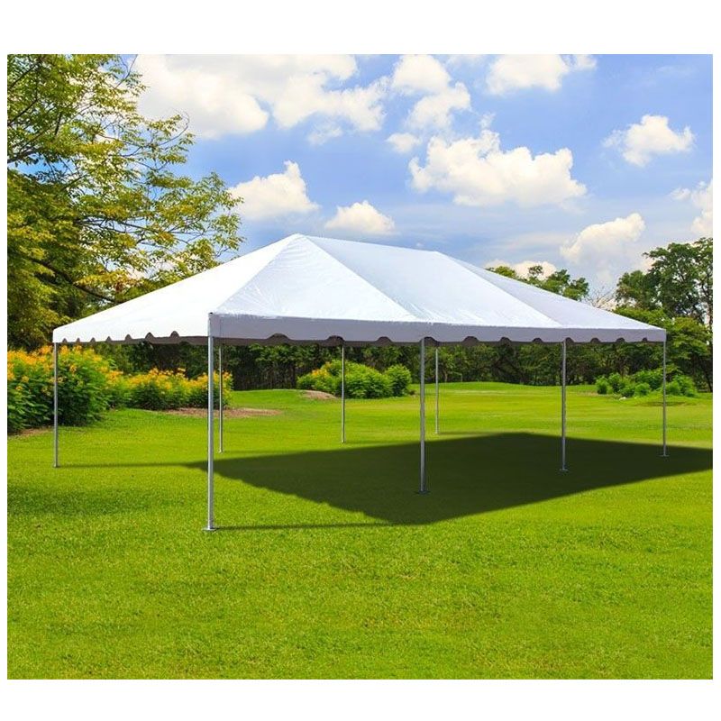 A large white tent is sitting in the middle of a lush green field