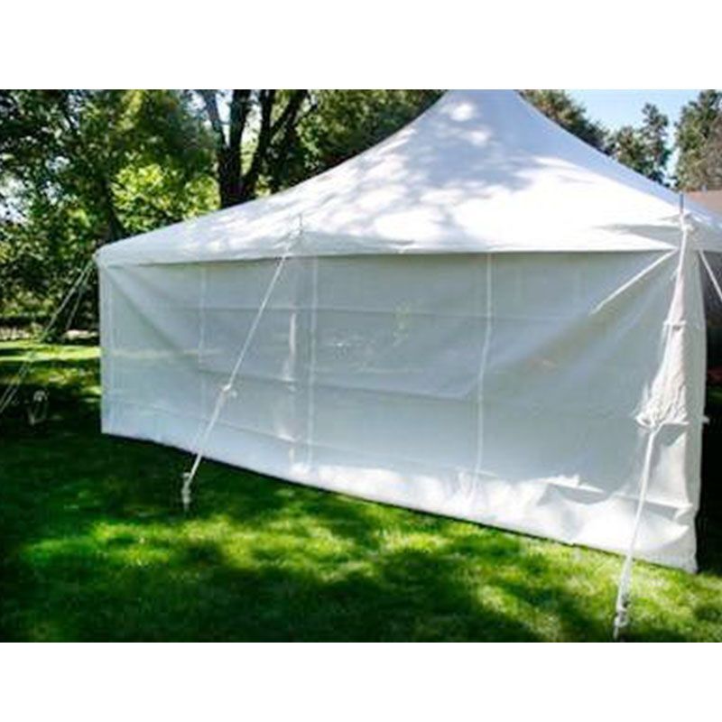 A white tent is sitting on top of a lush green field.