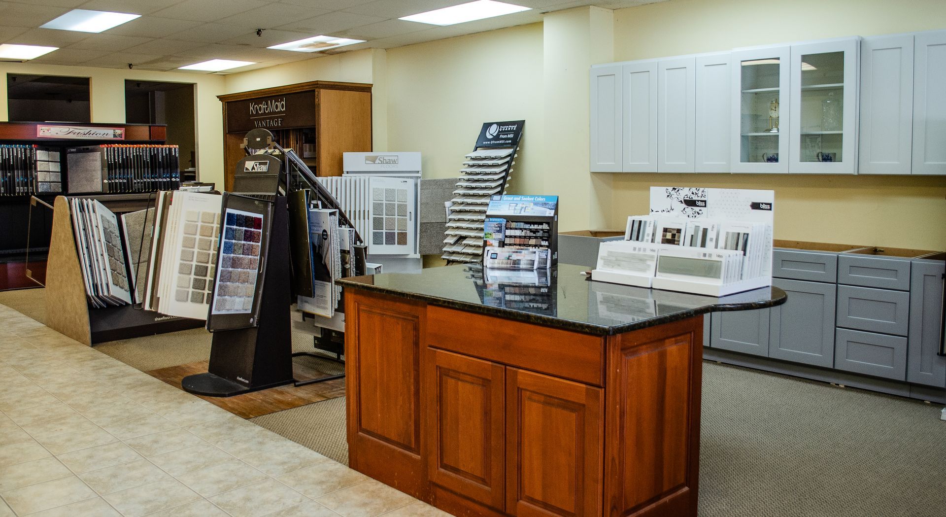a kitchen with white cabinets and a wooden island in the middle
