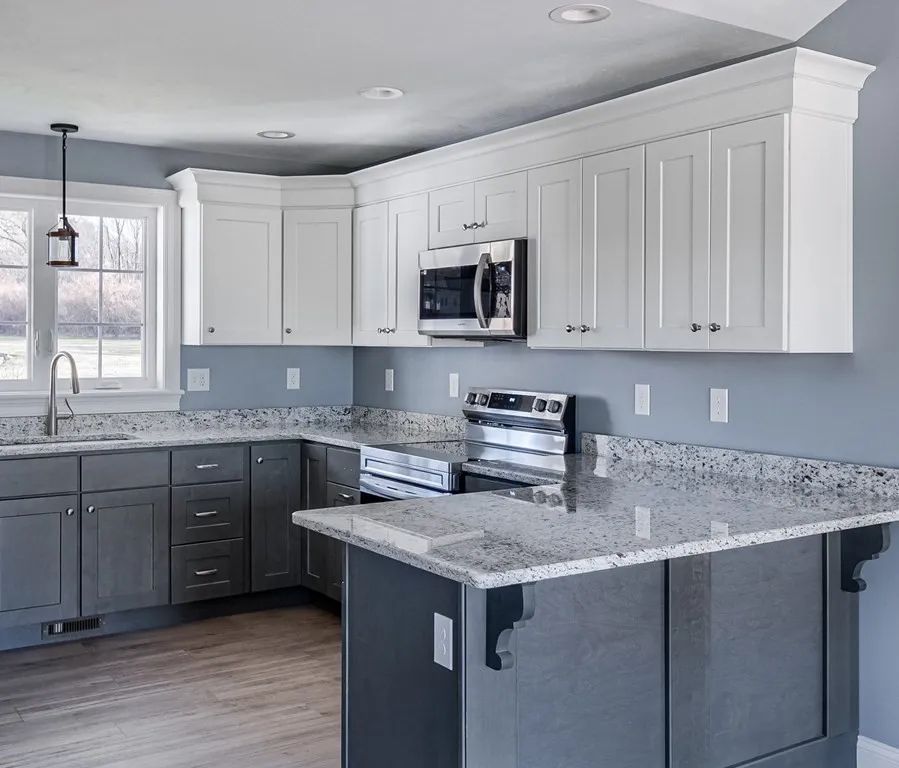 a kitchen with white cabinets and granite countertops