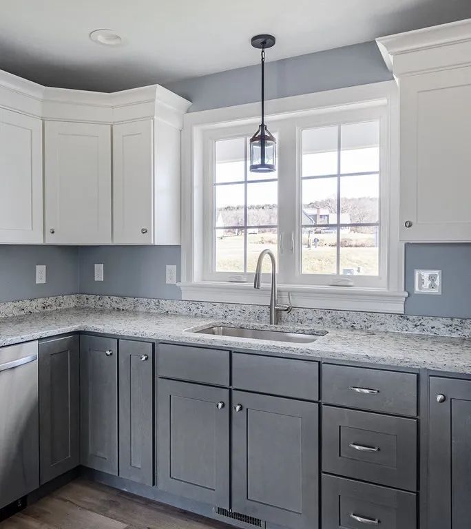a kitchen with gray cabinets and white cabinets and a sink