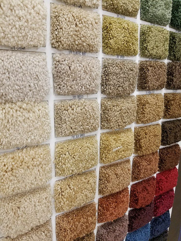 a wall filled with lots of different colored carpets