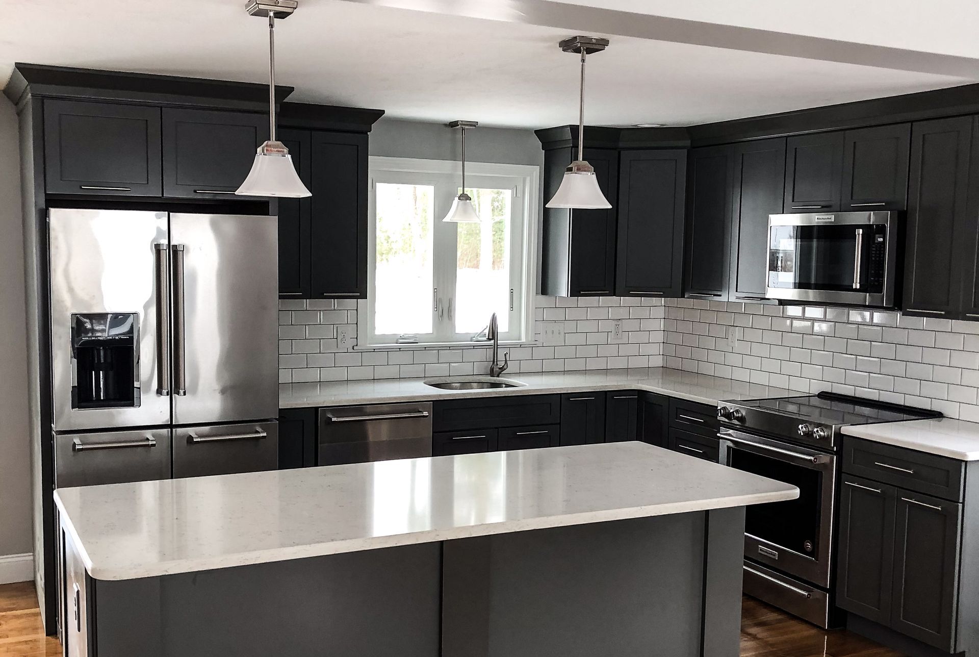 a kitchen with black cabinets and stainless steel appliances