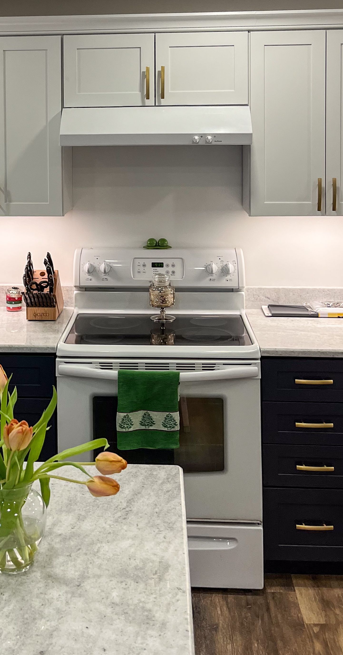 a kitchen with a refrigerator and a vase of flowers on the counter