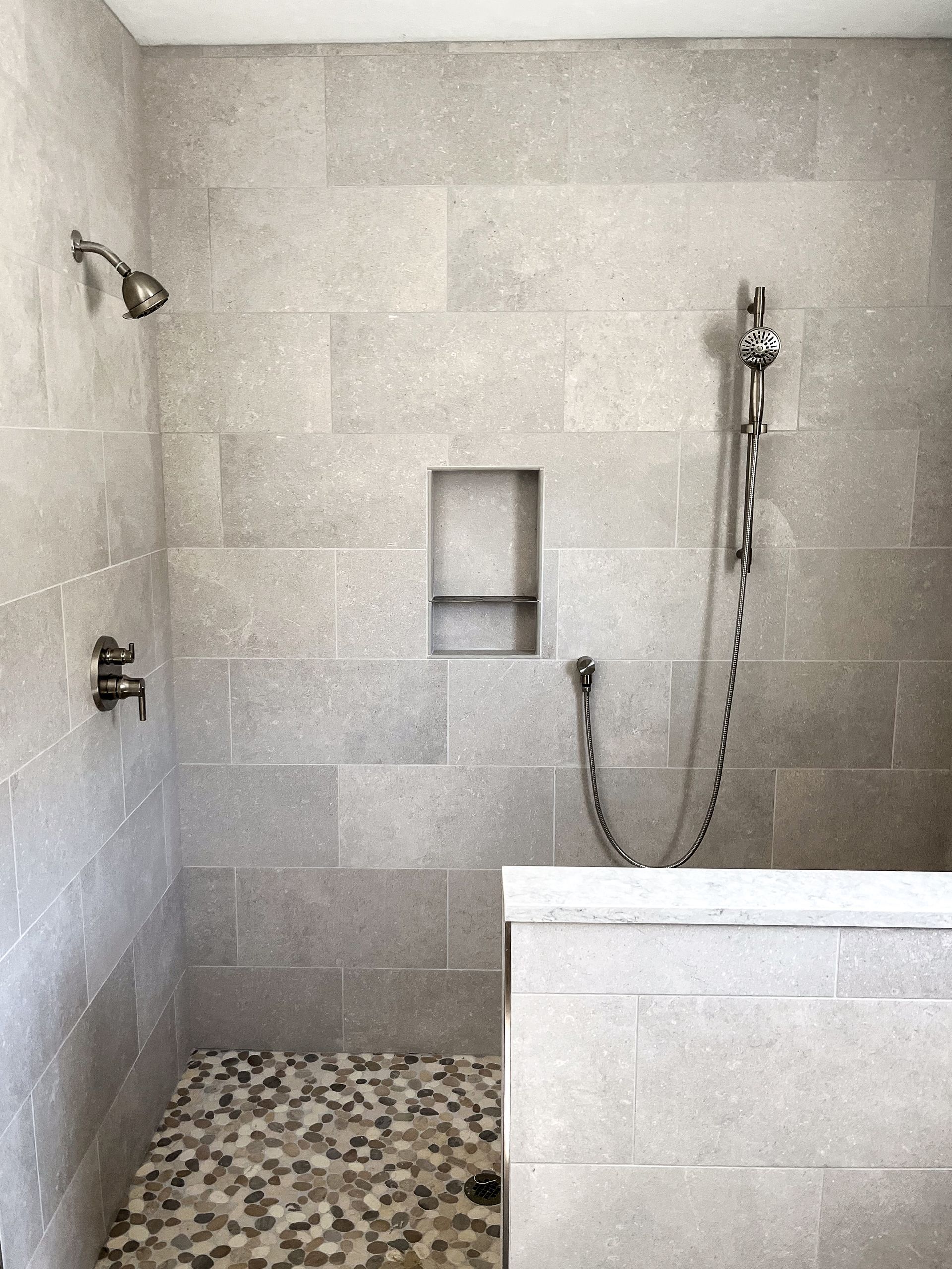 a white cabinet with a wooden countertop and a herringbone pattern on the wall