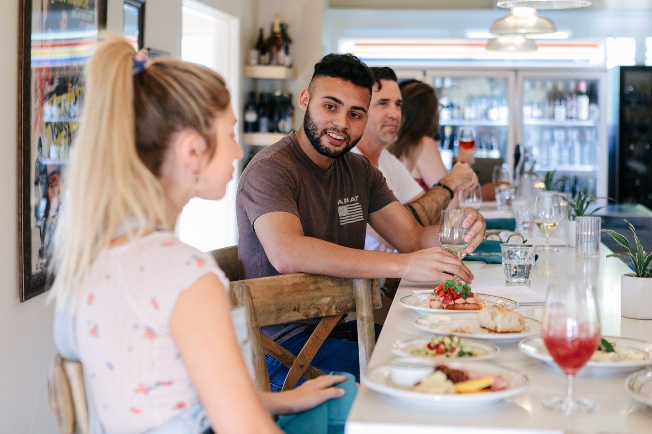 people sitting at the table with food on it
