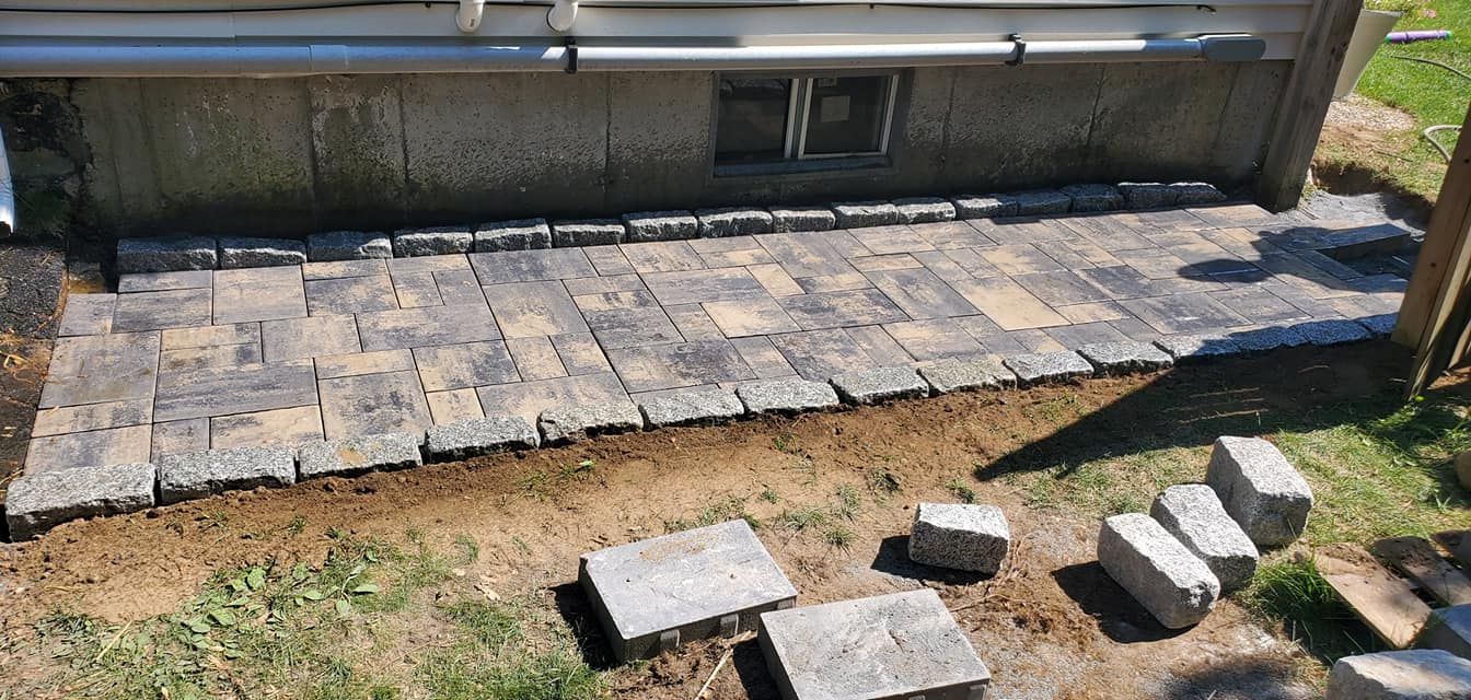 A stone walkway is being built in front of a house.