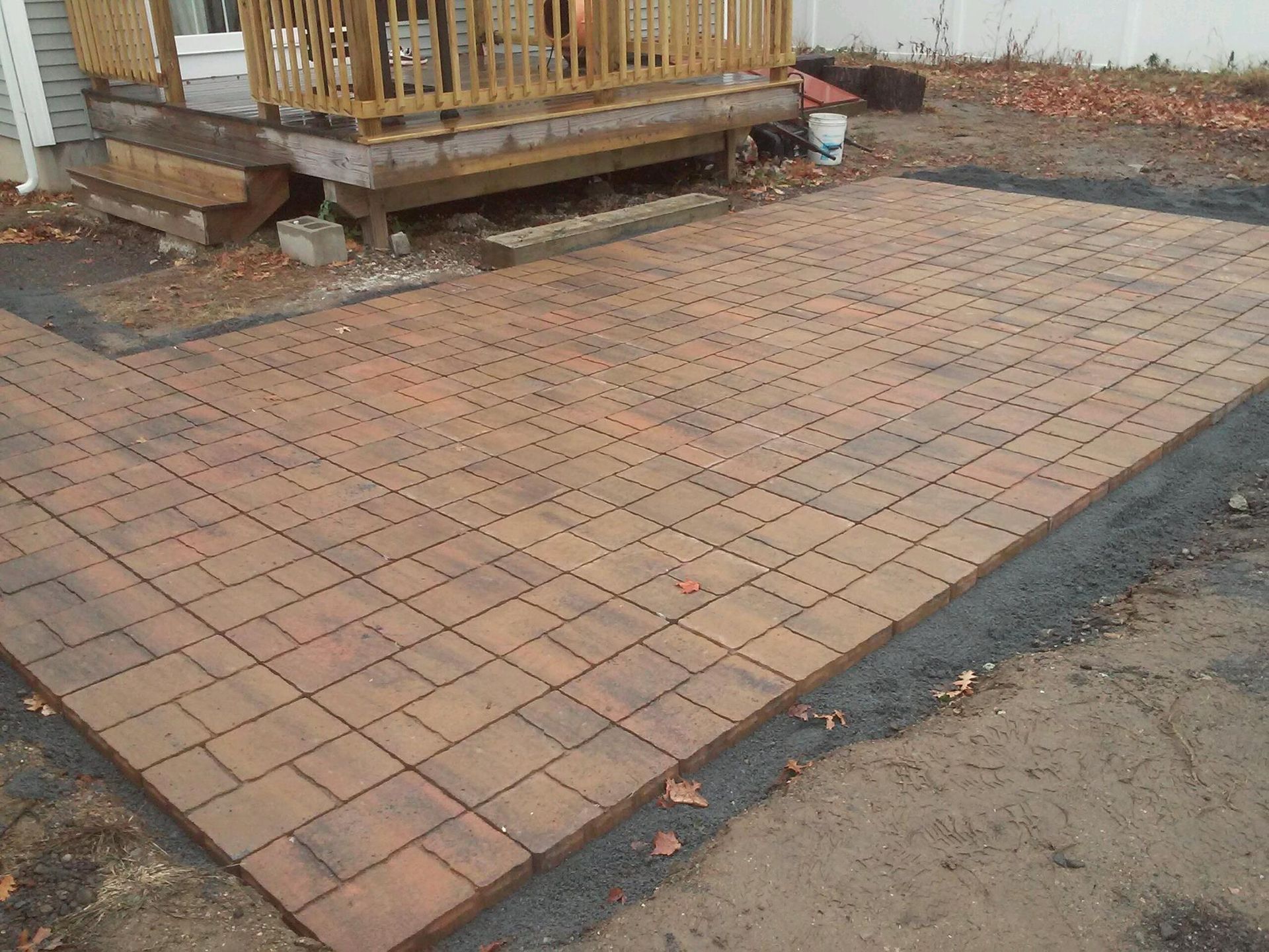A brick patio is being built in front of a house
