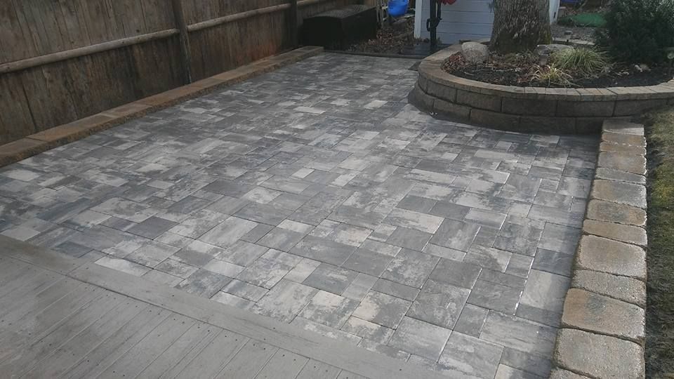 A patio with a tree in the middle of it and a fence in the background.