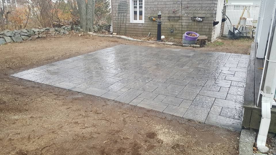 A patio is being built in the backyard of a house.
