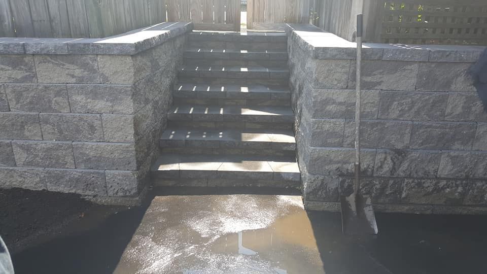 A set of stairs leading up to a brick wall.