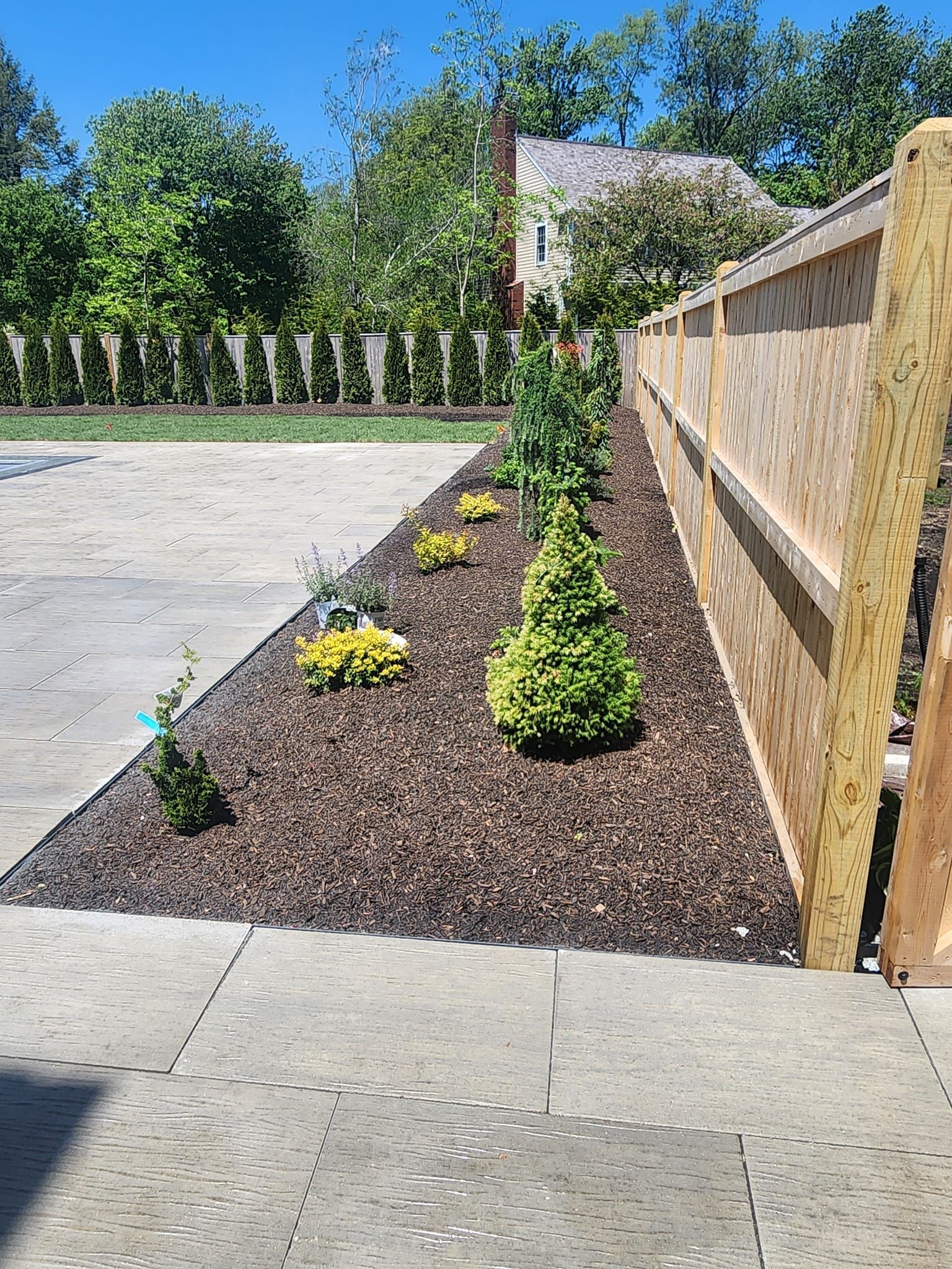 A wooden fence is surrounded by a lush green garden.