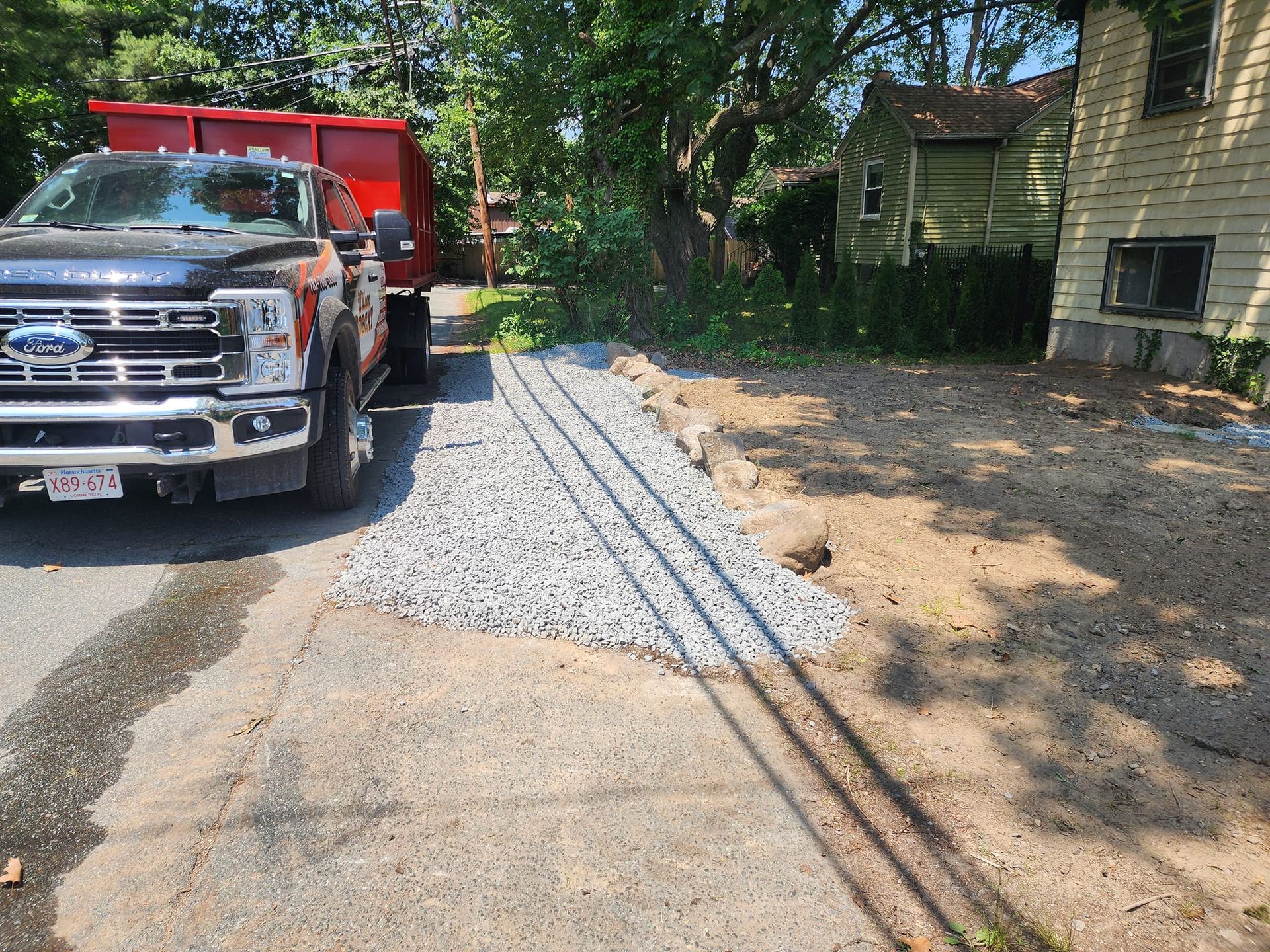 A dump truck is parked on the side of the road next to a house.
