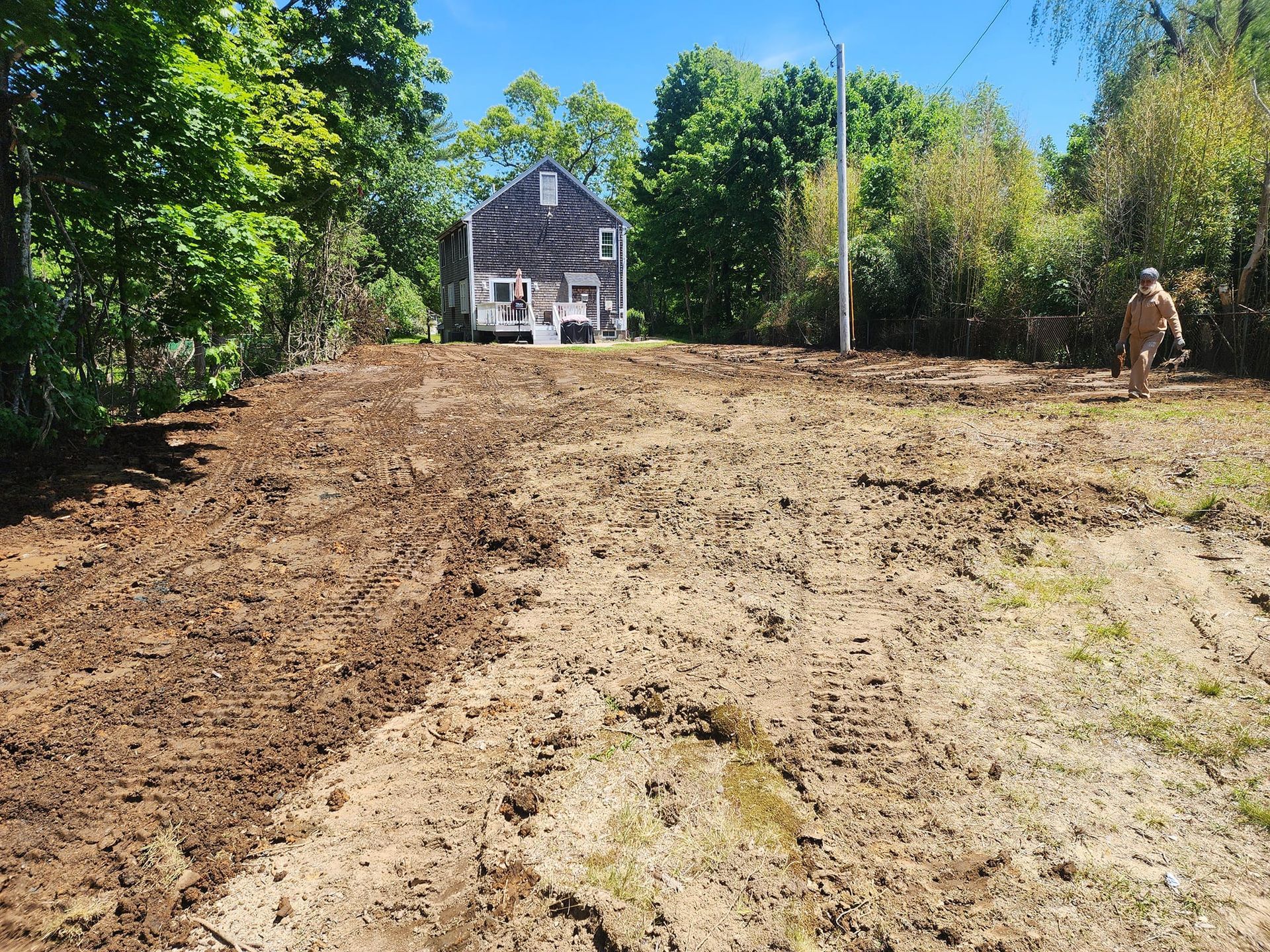 A muddy field with a house in the background.