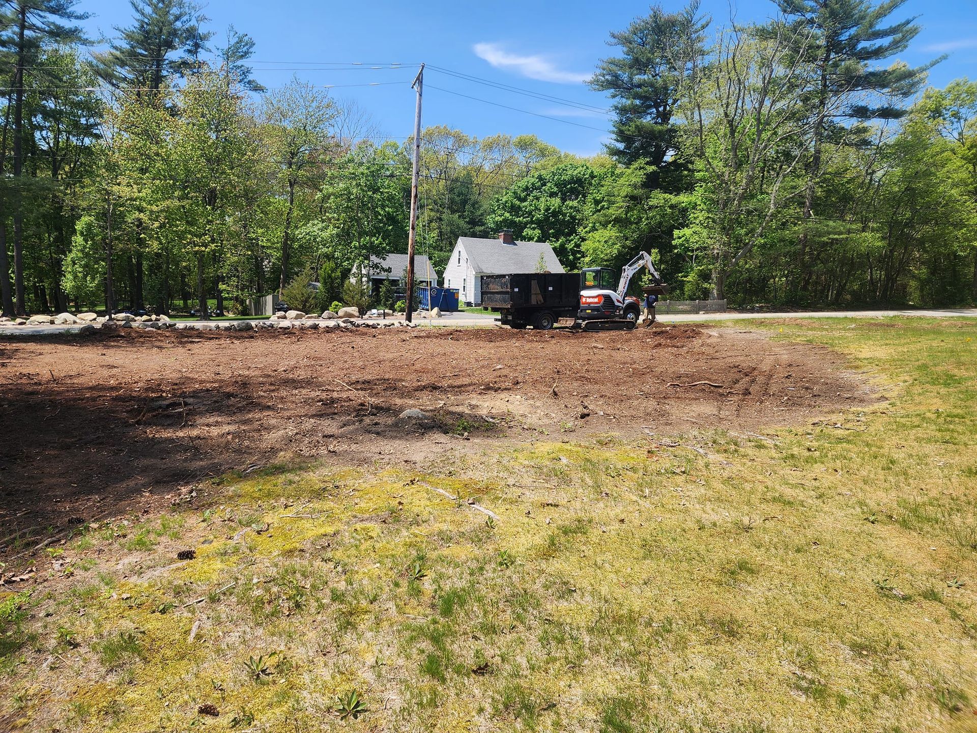 A dumpster is sitting in the middle of a grassy field.